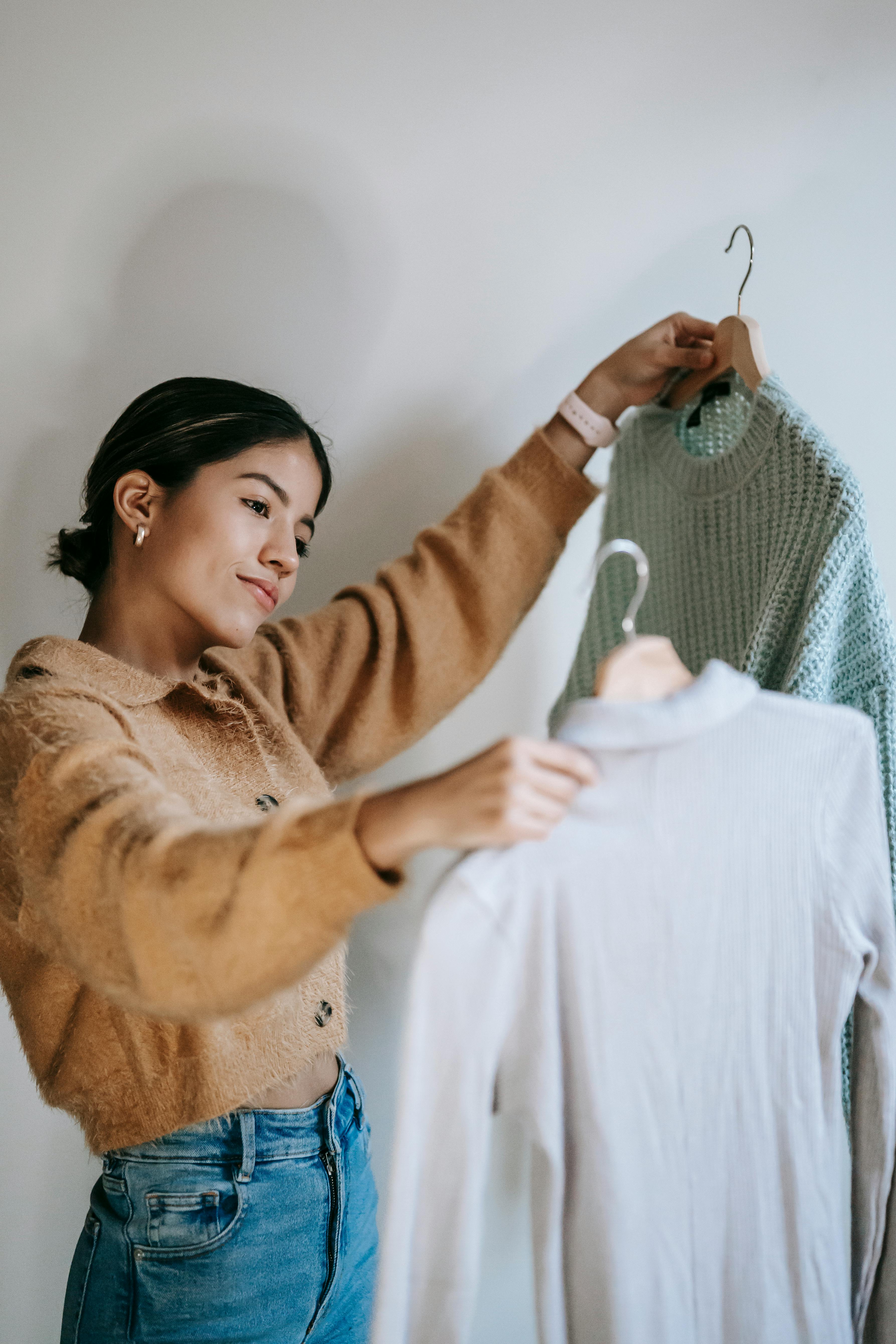 girl choosing between two capsule wardrobe shirts